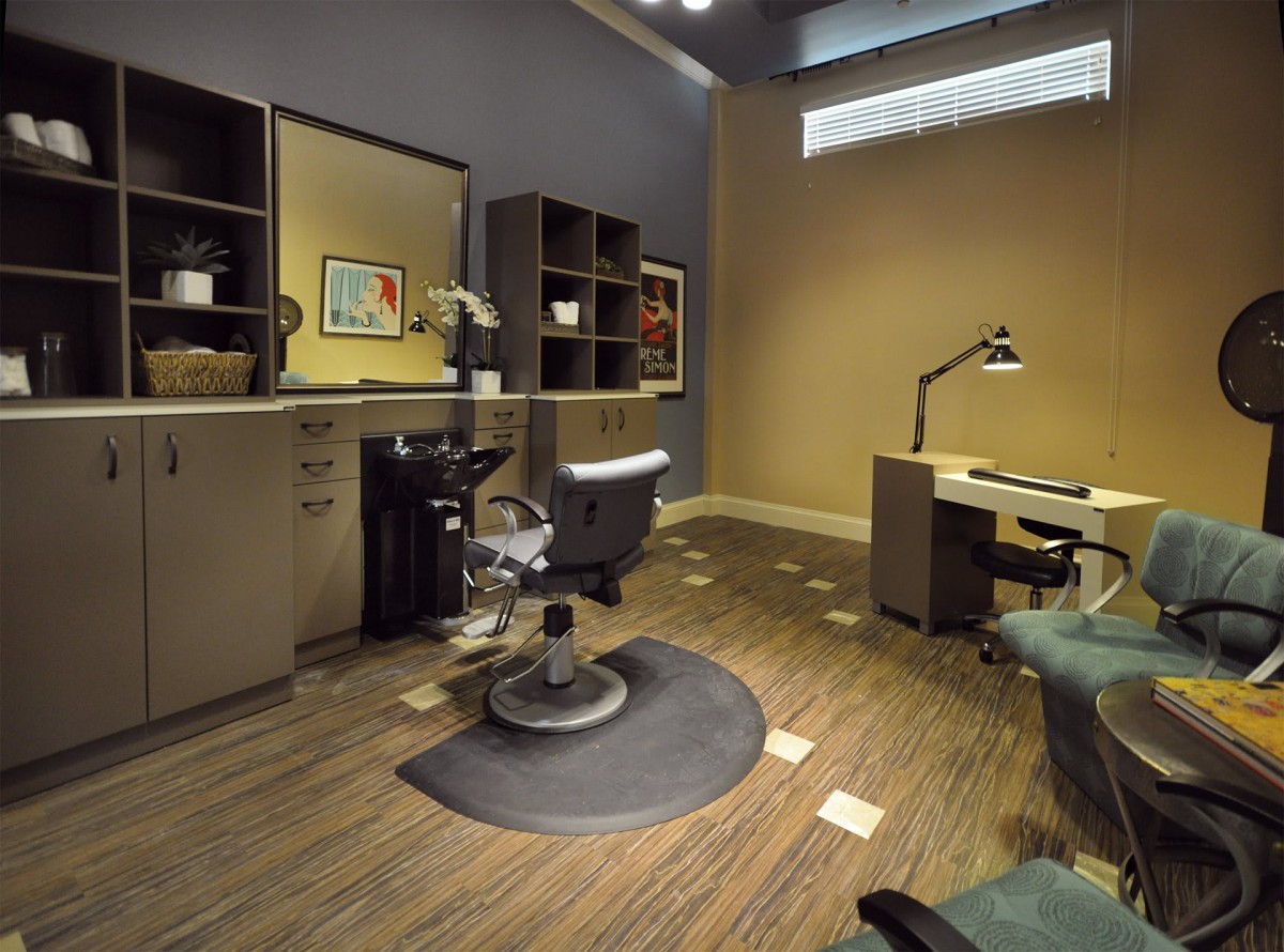A modern salon interior with a styling chair and workspace setup.