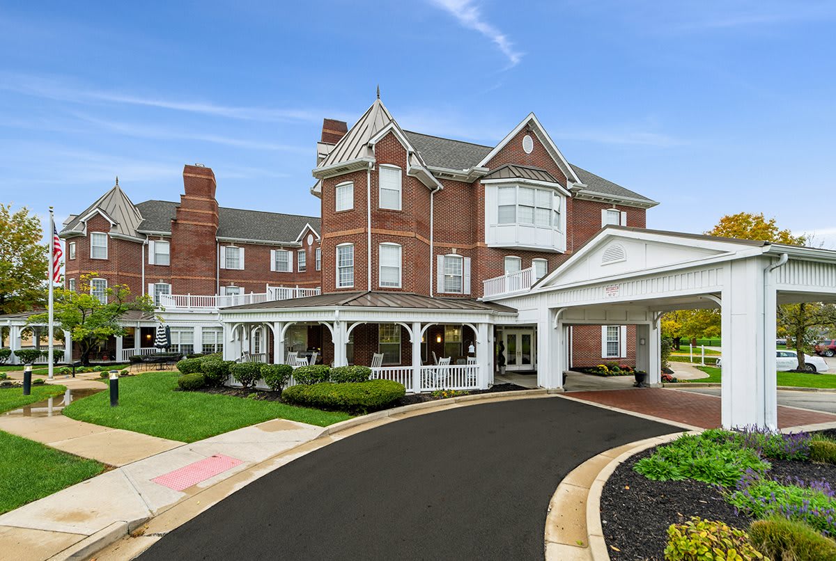 A classic brick hotel with a grand entrance and circular driveway set against a clear blue sky.