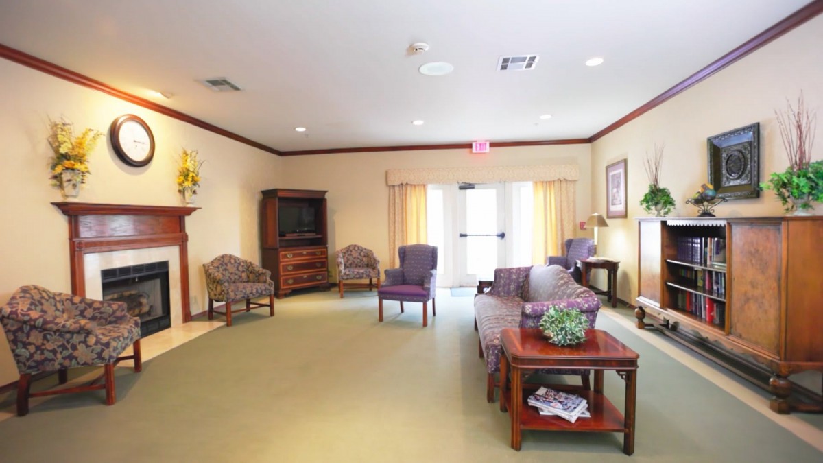A cozy living room with comfortable chairs, a coffee table, and a television.