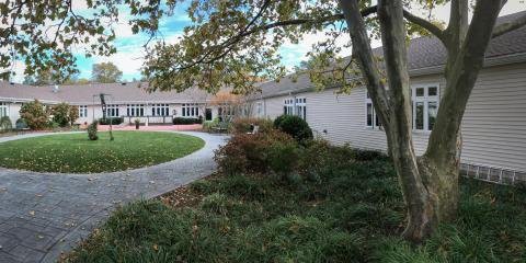 A serene view of a suburban house with a lush garden and pathway.