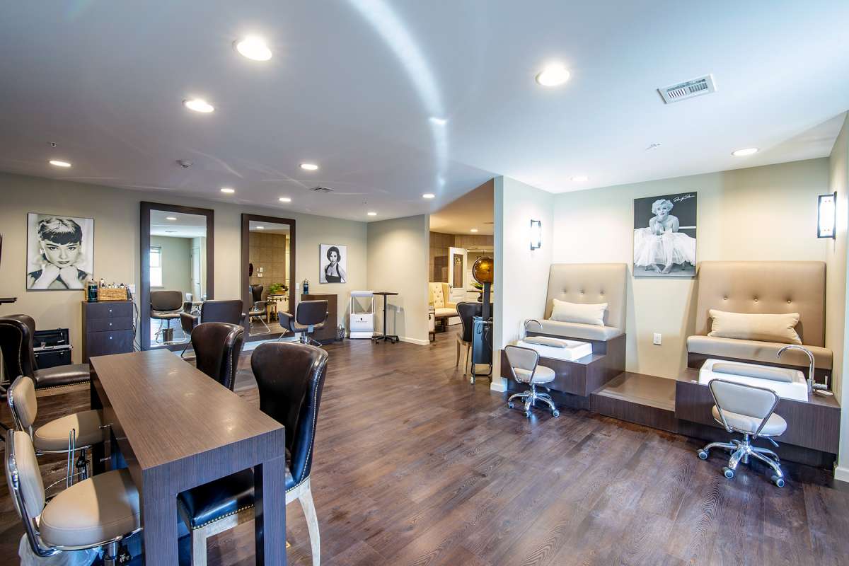 A modern and stylish salon interior featuring seating and mirrors.
