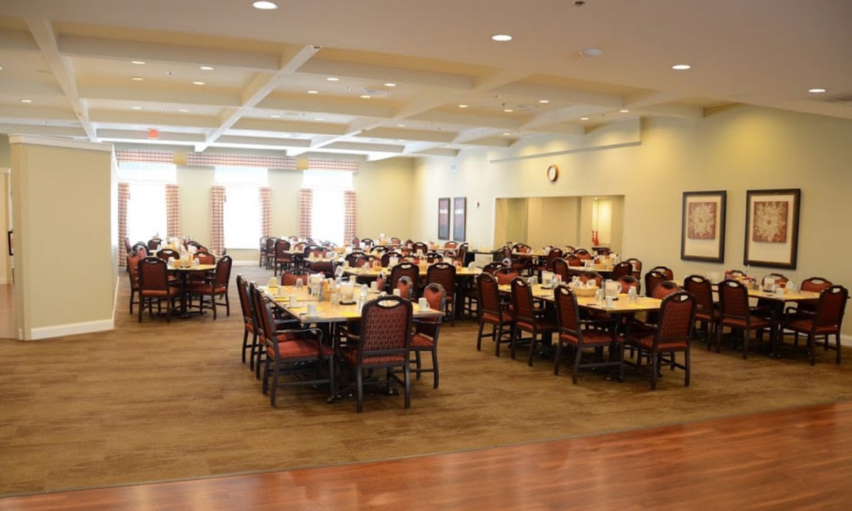 An empty dining hall with tables and chairs arranged neatly.