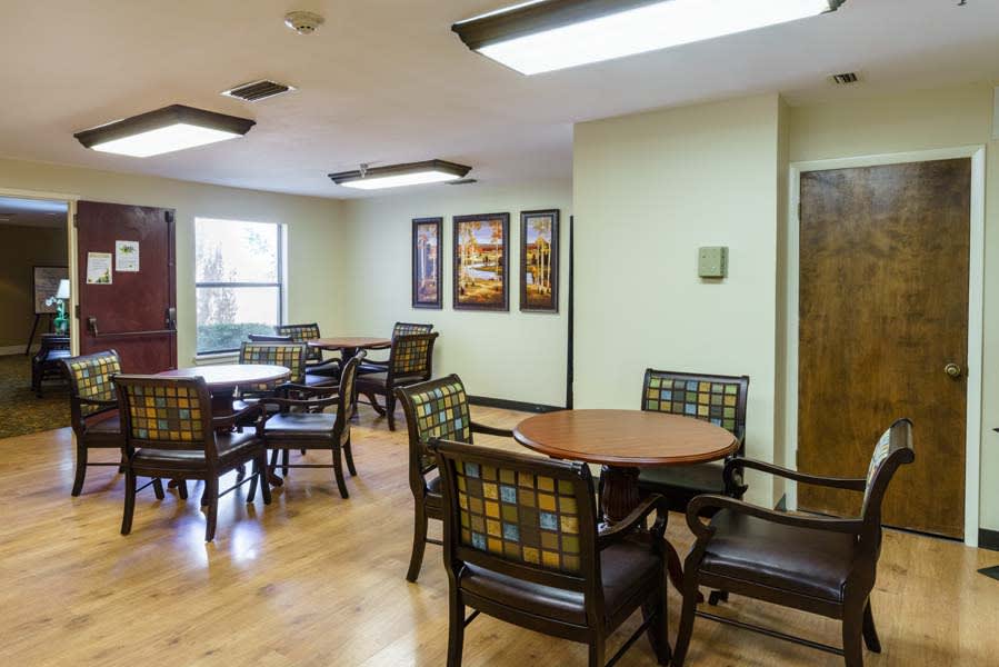 A cozy indoor dining area with tables and chairs arranged neatly under bright lighting.