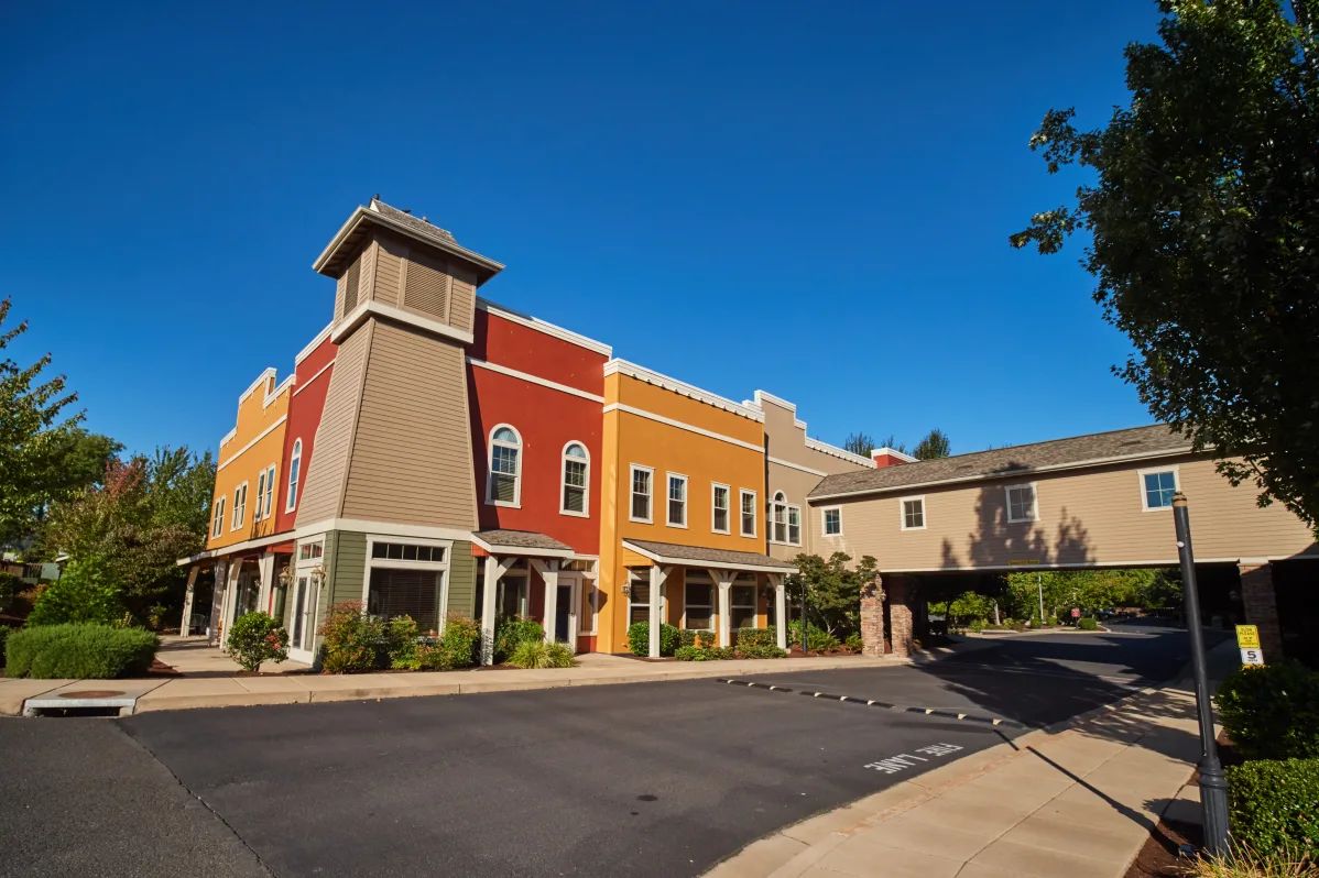 A vibrant commercial building complex under a clear blue sky.