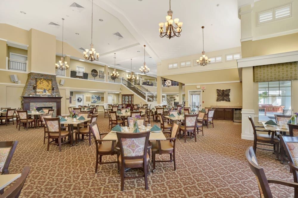 An elegant dining room with multiple tables and chandeliers.
