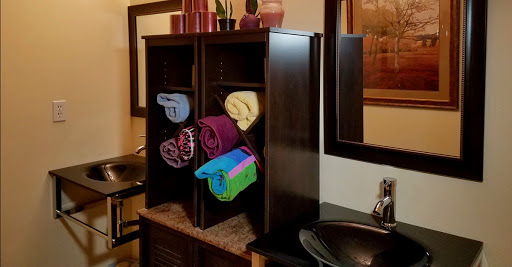 A stylish bathroom storage unit showcasing neatly rolled towels in various colors.