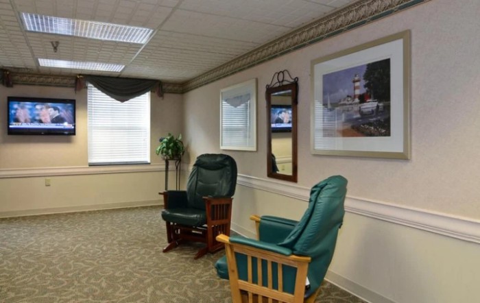 A cozy waiting room with comfortable chairs and decorative artwork on the walls.