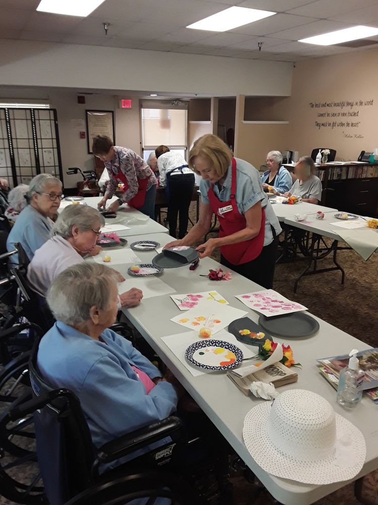 A group of elderly individuals engaged in an art and crafting activity at a community center.