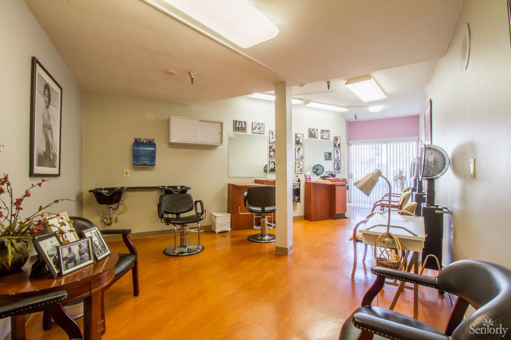 A well-lit salon interior with styling chairs and mirrors.