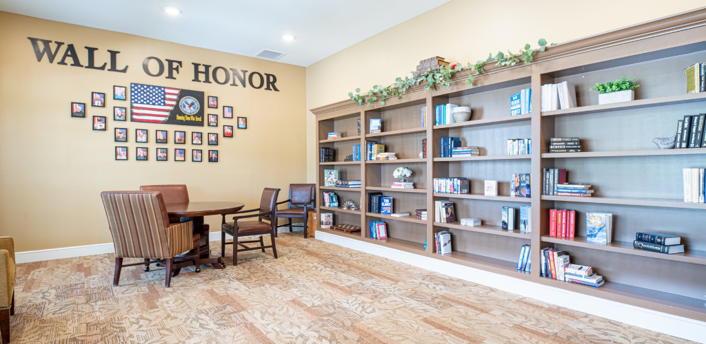 A cozy interior with bookshelves, a seating area, and a wall of honor.