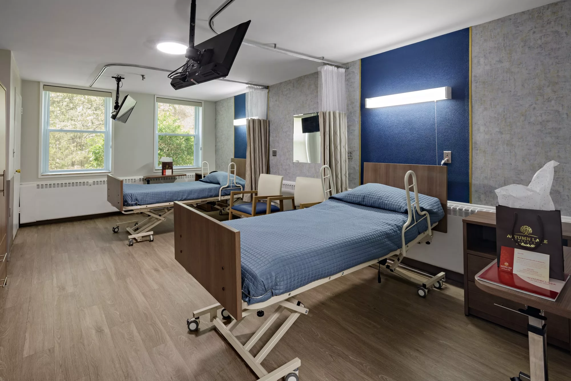 A modern hospital room with two patient beds, equipped with medical amenities.