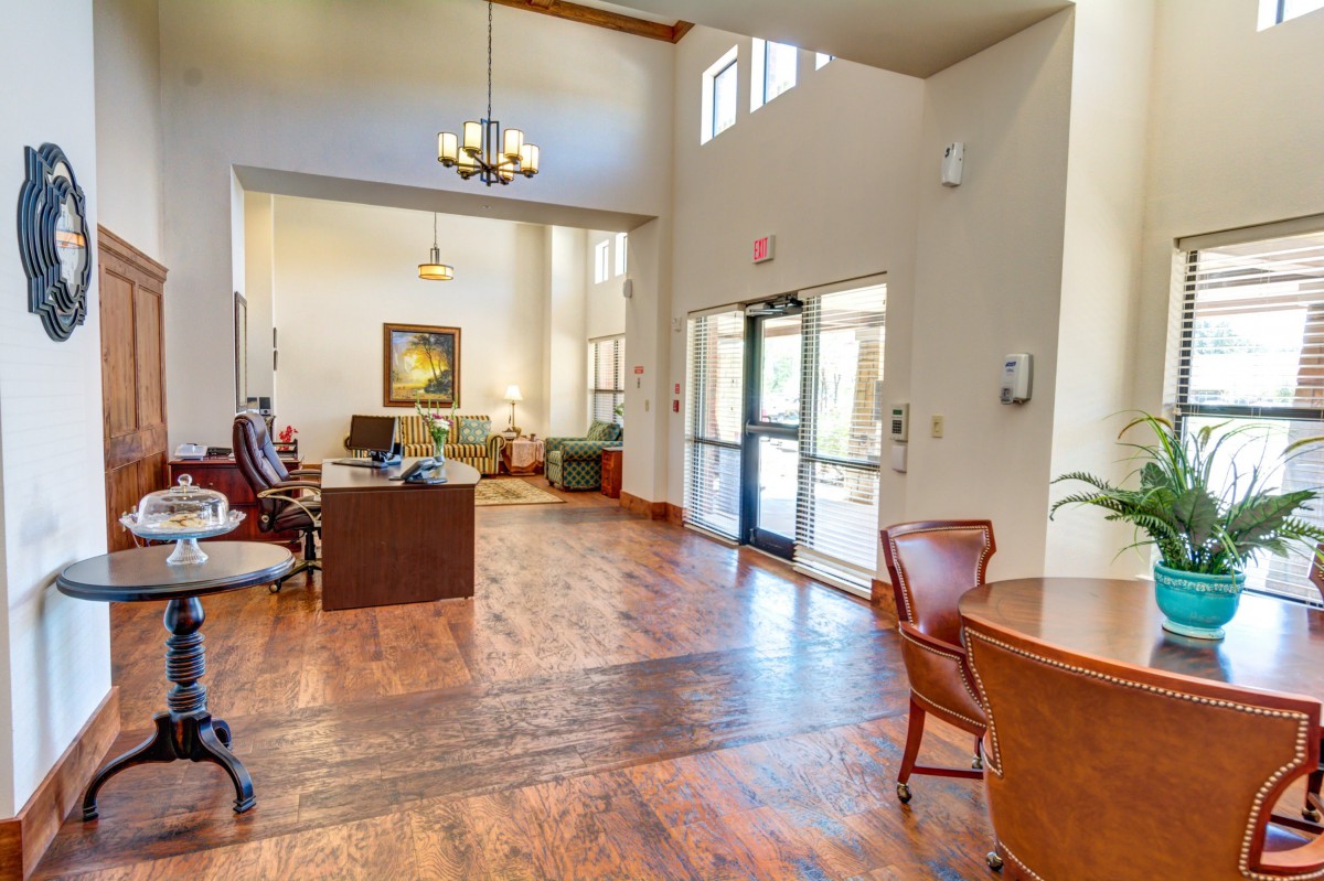 A spacious lobby with wooden flooring, ample natural light, and comfortable seating.