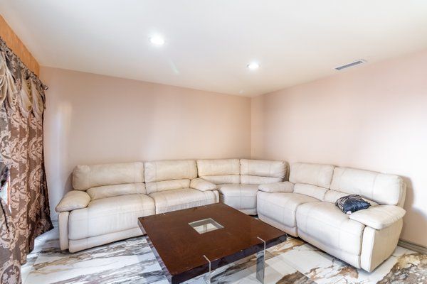 A modern living room with a beige corner sofa and a wooden coffee table.