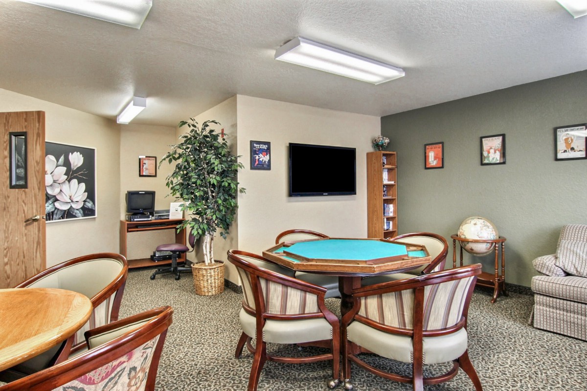 A spacious meeting room with a table, chairs, and office equipment.