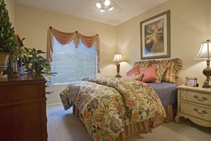 A cozy bedroom with a floral comforter and stylish decor.