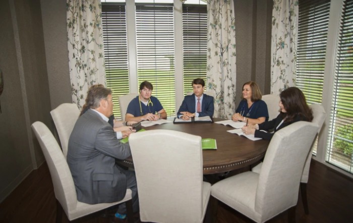 A group of individuals having a business meeting around a round table.