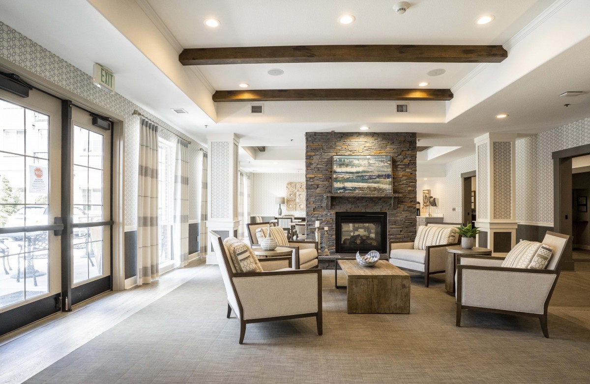 A modern and spacious living room with elegant furniture and a cozy fireplace.