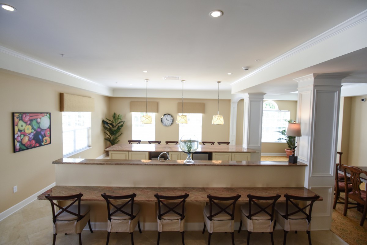 A modern kitchen interior with a long counter and stools.