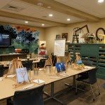 An art studio set up for a painting class, featuring easels and various art supplies.