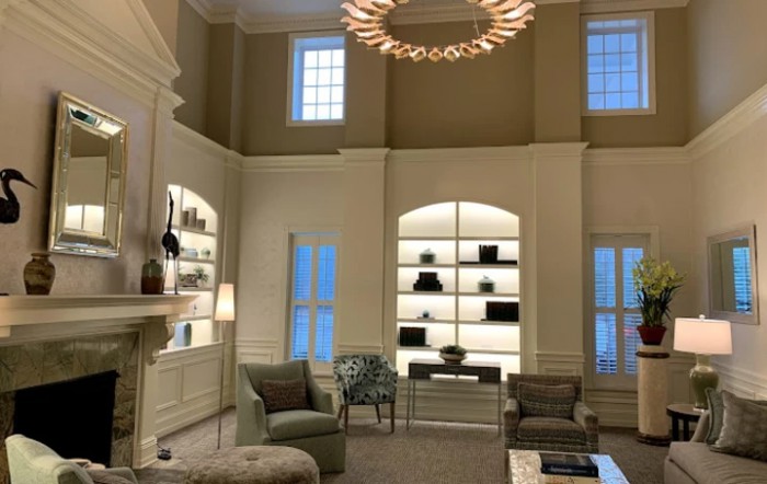 A luxurious living room with elegant furniture and a modern chandelier.