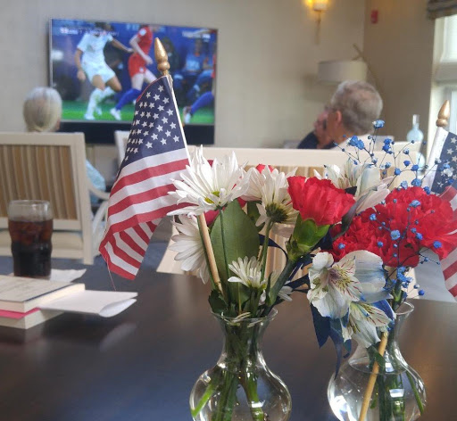 Enjoying a soccer game while celebrating with flowers and the American flag.