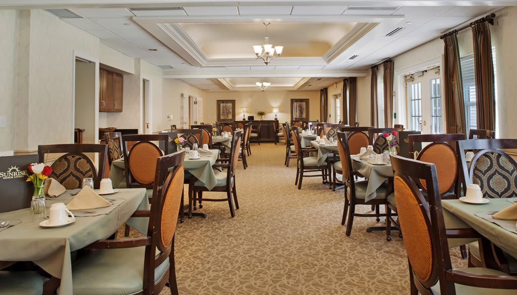 A spacious and elegant dining room with neatly arranged tables and chairs.