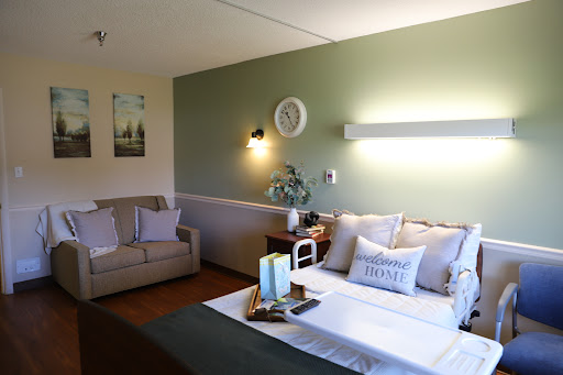 A cozy and elegantly styled bedroom featuring a green accent wall and inviting furnishings.