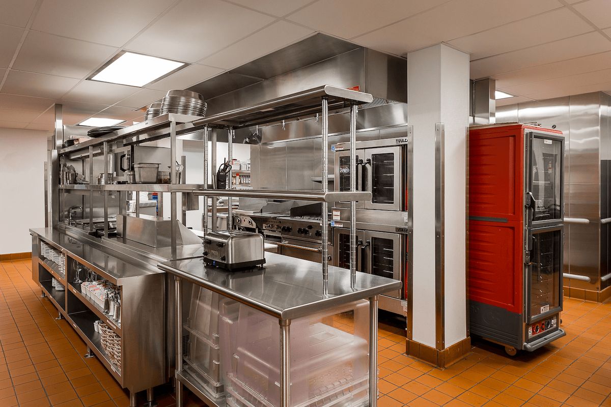 A well-organized commercial kitchen with stainless steel surfaces and industrial cooking equipment.