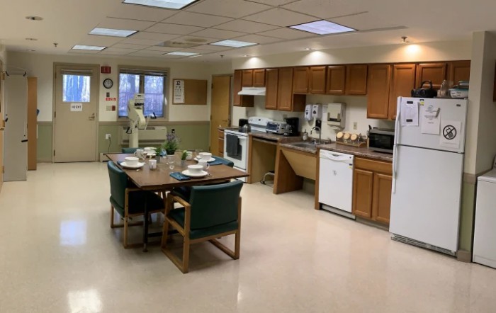 A spacious kitchen and dining area with appliances, cabinets, and a set dining table.