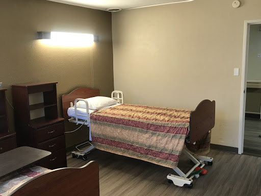 A clean and organized patient room in a healthcare facility, featuring a hospital bed and bedside furniture.