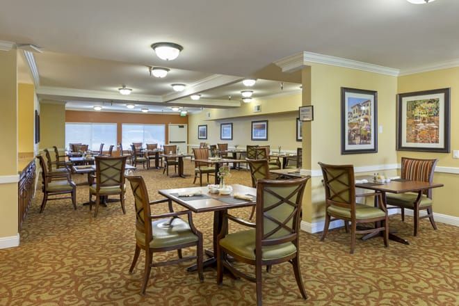An empty dining room with neatly arranged tables and chairs.