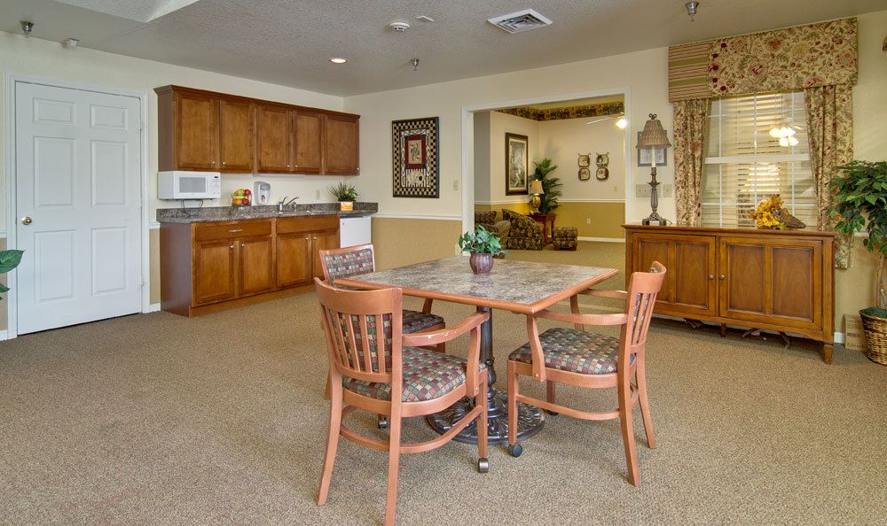 A cozy dining area with wooden furniture and a kitchenette.