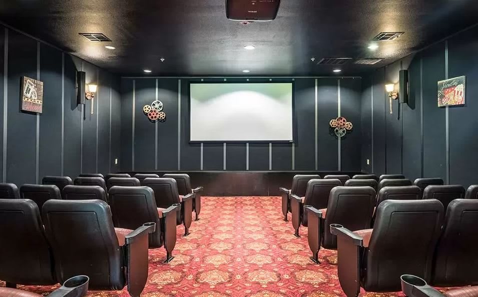 A cozy home theater with plush seating and a large screen.
