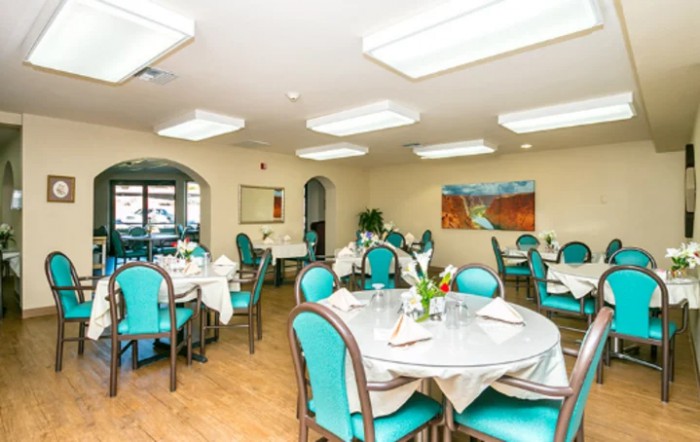 An elegant dining room with neatly arranged tables and chairs, featuring contemporary decor.