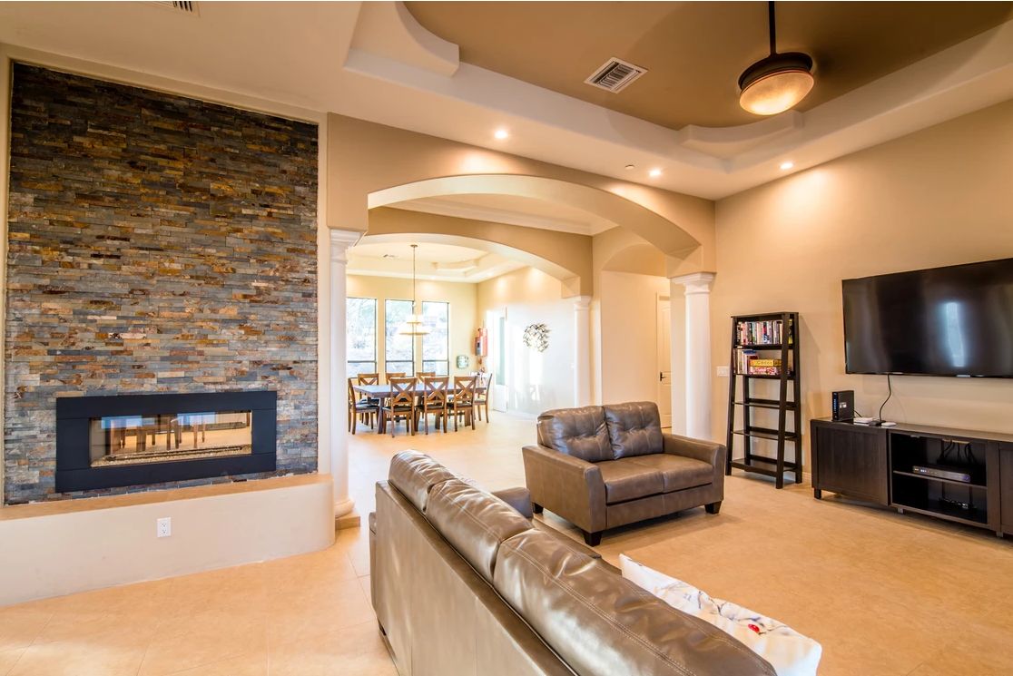 A modern living room featuring a cozy fireplace, elegant furniture, and stylish ceiling lights.