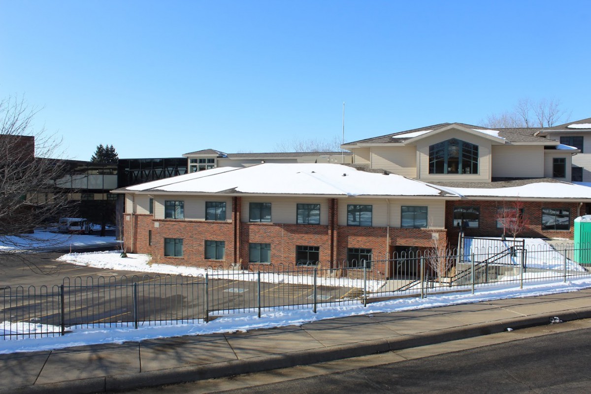A brick building surrounded by snow on a clear winter day.