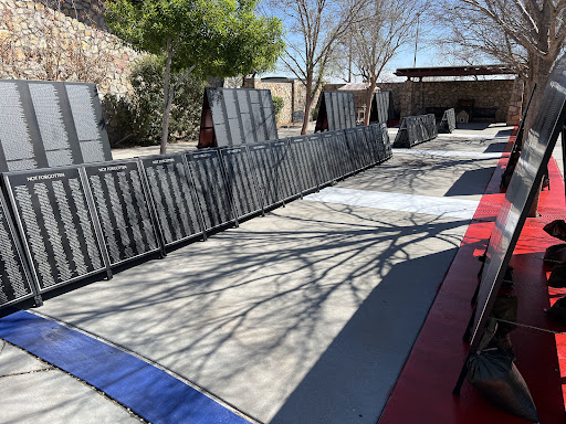 An outdoor training area featuring various obstacles and mats arranged on the pavement.