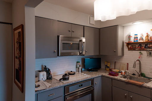 A modern kitchen featuring essential appliances and a cozy arrangement.