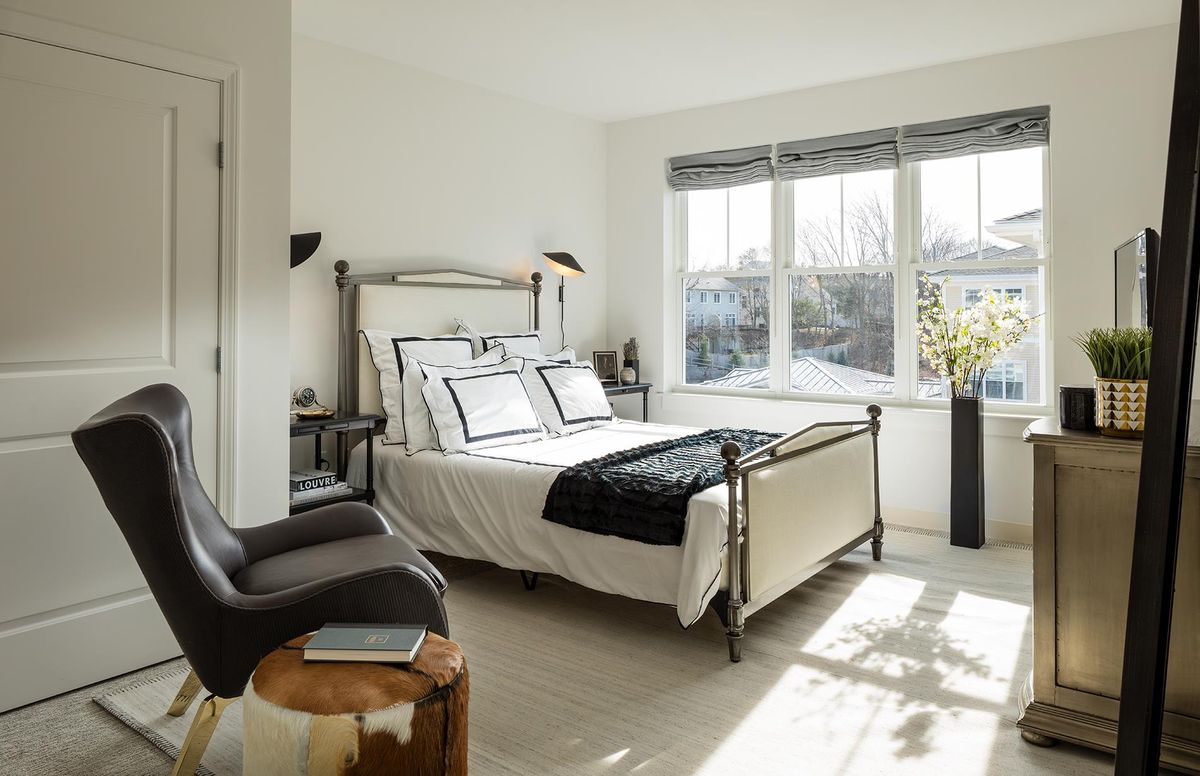 A bright and minimalist modern bedroom with large windows and stylish decor.