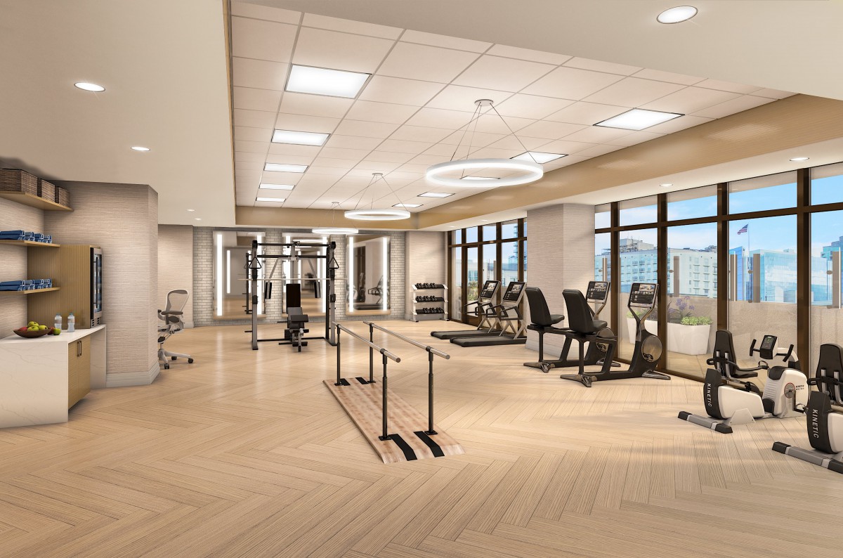 A spacious and bright gym equipped with fitness machines and exercise equipment.