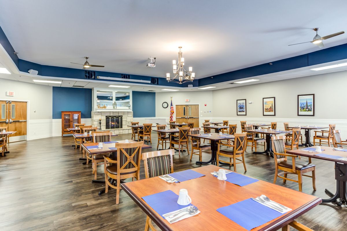 A spacious and well-lit restaurant dining area with neatly arranged tables and chairs.