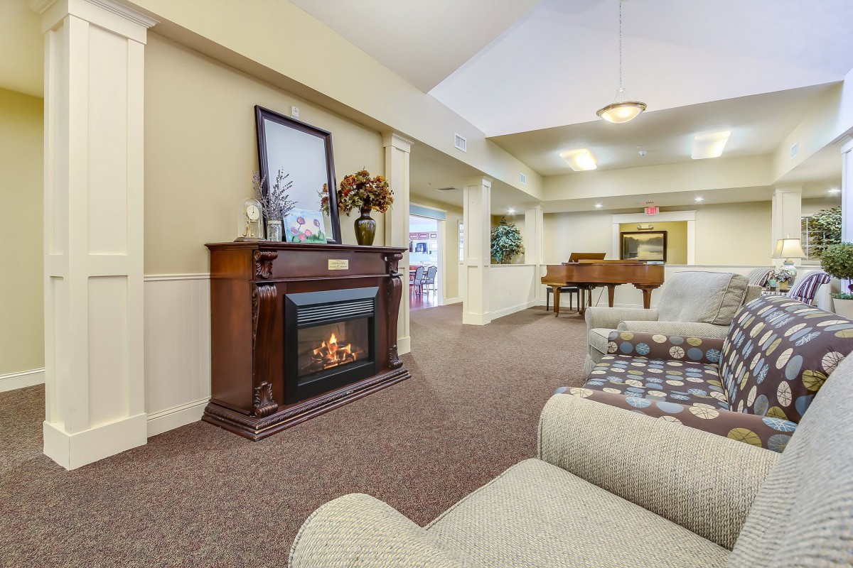 A cozy living room with a fireplace and a grand piano.