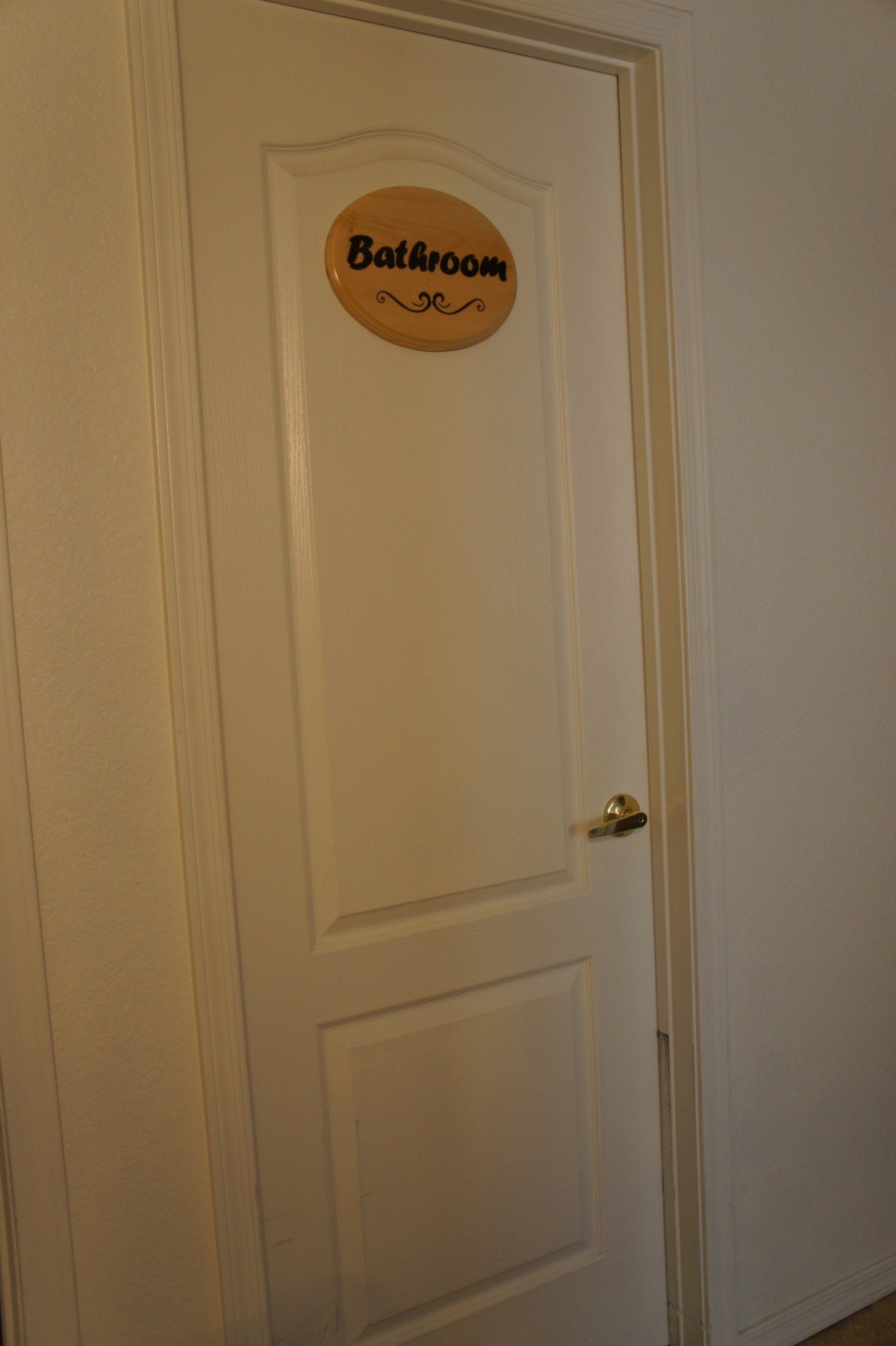 A closed door with a bedroom sign attached.