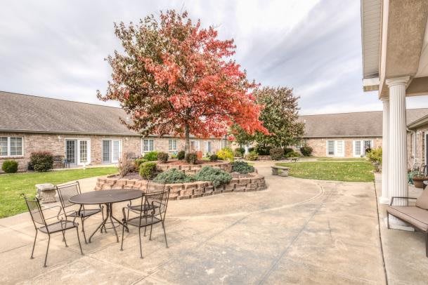 A peaceful courtyard with autumn trees and patio seating.