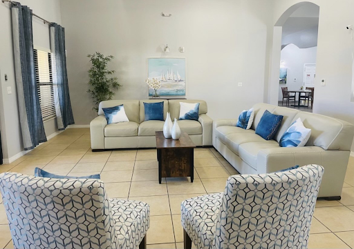 A cozy living room featuring modern furniture with blue accents and decorative artwork.