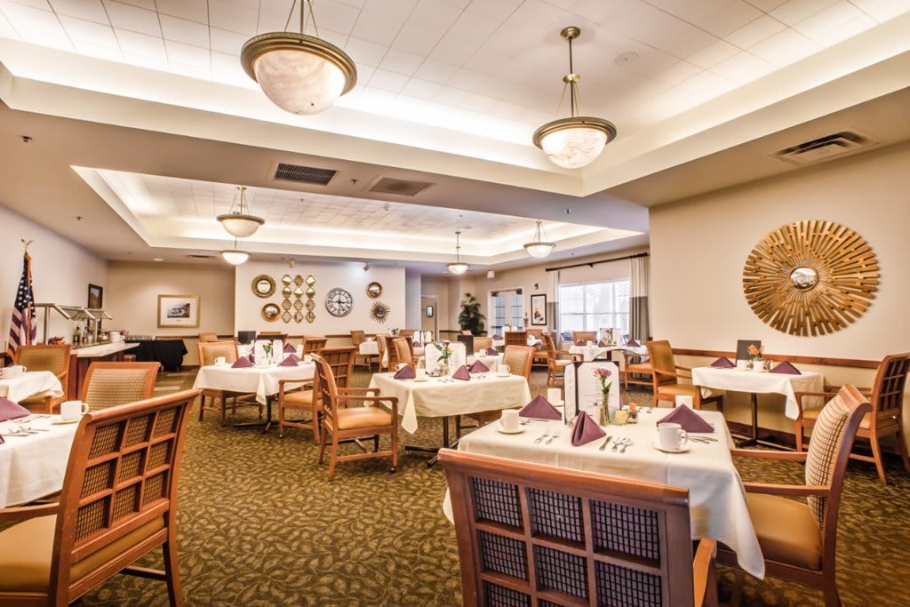 A spacious and elegantly decorated restaurant dining area with neatly arranged tables and chairs.