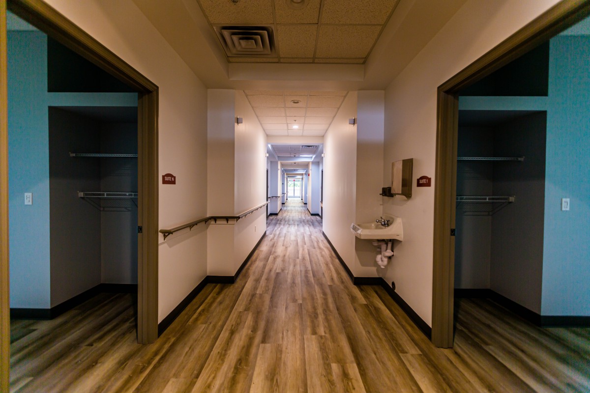 A well-lit hallway with multiple doors leading to different rooms.