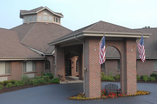 A brick building with an entrance featuring an American flag.