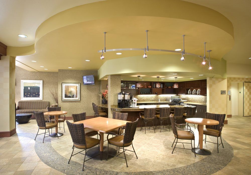 A modern cafe interior with tables, chairs, and stylish lighting.