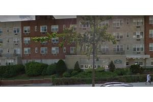 A residential apartment building with landscaping in front.